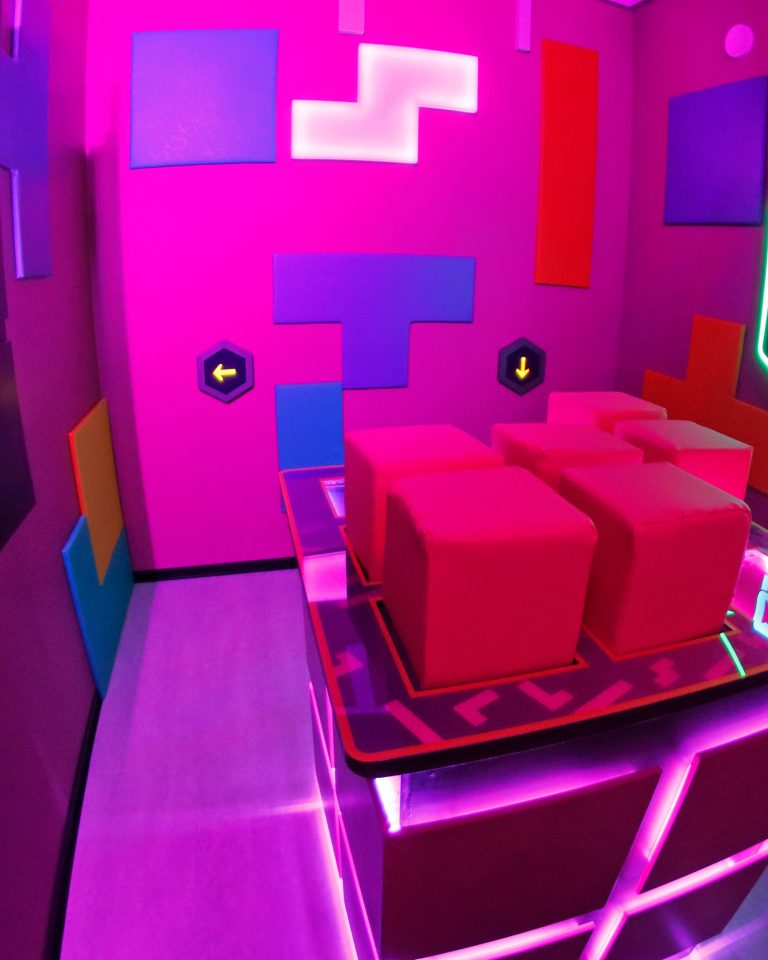Der Cube Challenges Raum "7 Blocks" mit einem großen Display und einem Retrospiel-Design